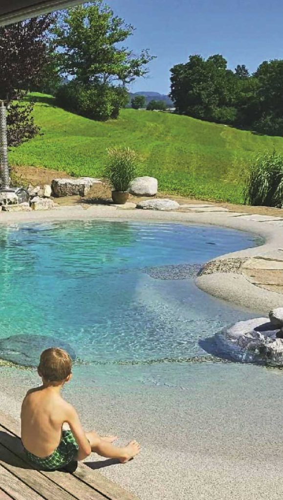 Niño sentado en el borde de una piscina de arena